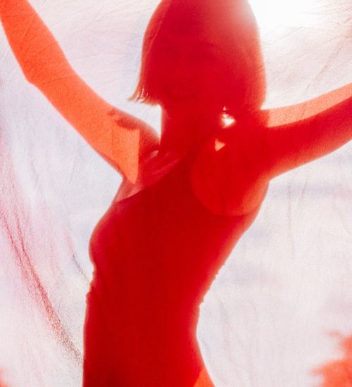 Woman feeling energetic and vibrant in a bright, abstract space.